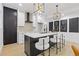 Bright kitchen features white cabinets, a black island, white countertops, modern light fixtures, and bar seating at 906 Mcdaniel St, Atlanta, GA 30310