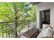 Private balcony with cozy outdoor seating area, overlooks lush greenery, providing a peaceful retreat at 245 N N Highland Ne Ave # 220, Atlanta, GA 30307