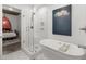 Bathroom showcases a modern glass shower, soaking tub, and stylish tile work next to a bedroom at 245 N N Highland Ne Ave # 220, Atlanta, GA 30307