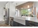 Modern kitchen features stainless steel appliances, a farmhouse sink, and an open layout to the living area at 245 N N Highland Ne Ave # 220, Atlanta, GA 30307