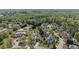 Aerial view of a neighborhood showcasing lush trees, a community pool, and tennis courts on a sunny day at 2625 Cross Springs Dr, Cumming, GA 30041