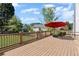 Spacious wood deck featuring a red umbrella providing shade and a view of the backyard at 2625 Cross Springs Dr, Cumming, GA 30041