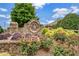 Stone community sign amidst lush landscaping and flowering plants at 2625 Cross Springs Dr, Cumming, GA 30041
