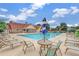 Relaxing community pool surrounded by lounge chairs and umbrellas with beautiful clubhouse at 2625 Cross Springs Dr, Cumming, GA 30041