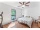 Light filled bedroom with hardwood floors, ceiling fan, and large window showcasing the lush landscaping at 305 Summit North Ne Dr # 305, Atlanta, GA 30324