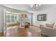 Bright living room with hardwood floors, modern lighting, and French doors leading to the sunroom at 305 Summit North Ne Dr # 305, Atlanta, GA 30324