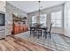 Charming dining room with a rustic brick wall, elegant chandelier, and wood-look flooring, perfect for entertaining at 6380 Cortland Walk, Alpharetta, GA 30005