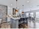 Spacious kitchen with an island, pendant lighting, stainless steel appliances, and a brick accent wall, great for gatherings at 6380 Cortland Walk, Alpharetta, GA 30005