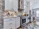 Modern kitchen with stainless steel appliances, white cabinetry, and a brick backsplash, perfect for culinary enthusiasts at 6380 Cortland Walk, Alpharetta, GA 30005