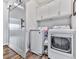Well-equipped laundry room featuring washer, dryer, white cabinetry, and stylish sliding barn door at 6380 Cortland Walk, Alpharetta, GA 30005