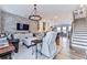 Spacious open-concept living room featuring brick accent wall, modern lighting, and an adjacent kitchen at 6380 Cortland Walk, Alpharetta, GA 30005