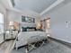 Bright primary bedroom showcasing a tray ceiling, modern furniture, and an ensuite bathroom at 6380 Cortland Walk, Alpharetta, GA 30005