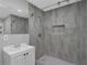 Modern bathroom featuring gray tiled walls, a shower with updated fixtures, and a sleek vanity with a sink at 3326 Chappel Lane, Peachtree Corners, GA 30360
