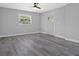 Well-lit bedroom with light gray walls, sleek gray floors, and a ceiling fan fixture at 3326 Chappel Lane, Peachtree Corners, GA 30360