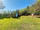 Spacious backyard features mature trees, lush lawn, playset, and a fence for privacy and security at 5485 Mountain Top Pl, Cumming, GA 30041