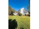 Spacious backyard with a well-maintained lawn, mature trees, and a white house at 5485 Mountain Top Pl, Cumming, GA 30041