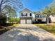 Charming two-story home with a two-car garage and a long driveway, surrounded by lush greenery at 5485 Mountain Top Pl, Cumming, GA 30041