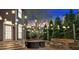 Charming backyard with a stone patio, an outdoor fire pit, and elegant string lights at 850 Highland Bend Cv, Alpharetta, GA 30022