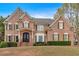 Elegant brick home featuring a symmetrical facade, detailed shutters, and manicured landscaping at 850 Highland Bend Cv, Alpharetta, GA 30022