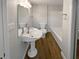 Well-lit bathroom featuring a pedestal sink, modern fixtures, and a tub-shower combination at 8608 Creekview Ct, Douglasville, GA 30135