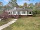 Charming home with manicured lawn, blooming tree, and inviting staircase leading to the front door at 8608 Creekview Ct, Douglasville, GA 30135