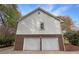 Two-car garage featuring white doors and brick accents at 8608 Creekview Ct, Douglasville, GA 30135