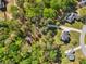 An aerial view captures multiple homes in the middle of a lush green landscape of mature trees at 1961 Flowering Dr, Grayson, GA 30017