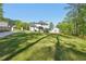 A well-maintained, expansive green backyard leads up to a modern two-story house with a deck at 1961 Flowering Dr, Grayson, GA 30017