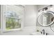 Bathroom with modern vanity, round mirror and a window offering natural light and a view at 1961 Flowering Dr, Grayson, GA 30017