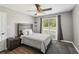 Cozy bedroom featuring a rustic wood headboard, ceiling fan, and natural light at 1961 Flowering Dr, Grayson, GA 30017