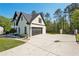 A spacious driveway leads to a two-story home with a prominent garage and landscaped yard at 1961 Flowering Dr, Grayson, GA 30017