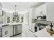 Modern kitchen with white cabinets, quartz counters, stainless steel appliances, and a view of the dining area at 1961 Flowering Dr, Grayson, GA 30017