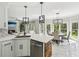 Open kitchen featuring white cabinetry, stainless steel appliances, and an island with quartz countertop at 1961 Flowering Dr, Grayson, GA 30017