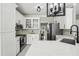 Modern kitchen featuring white cabinets, stainless steel appliances, quartz countertop, and tile backsplash at 1961 Flowering Dr, Grayson, GA 30017
