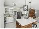 Stylish kitchen featuring white cabinets, stainless steel appliances, quartz countertops, and wood accents on the island at 1961 Flowering Dr, Grayson, GA 30017