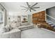 Bright open-concept living room with large sectional, hardwood accent wall and staircase at 1961 Flowering Dr, Grayson, GA 30017