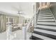 Bright open-concept living room with large sectional and stairs leading to the upper level at 1961 Flowering Dr, Grayson, GA 30017
