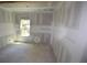 A bright bedroom featuring drywall, large windows with wooded views, and unfinished flooring at 3689 Ashwood Se Dr, Smyrna, GA 30080