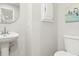 Bathroom with a pedestal sink, a toilet, a mirrored cabinet, and a painting on the wall at 1183 Woods Ne Cir, Atlanta, GA 30324