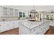 Well-lit kitchen featuring an oversized granite island, white cabinets, and stainless steel appliances at 1183 Woods Ne Cir, Atlanta, GA 30324
