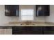 Close-up of stainless steel kitchen sink with granite countertops and dark cabinets at 160 Weldon Rd, Mcdonough, GA 30253
