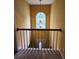 Stair landing featuring a decorative light fixture and large arched window for ample natural lighting at 645 Birchberry Sw Ter, Atlanta, GA 30331