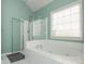 Bright and airy main bathroom with a luxurious soaking tub, glass enclosed shower, and large window at 2810 Stillwater Park Dr, Marietta, GA 30066