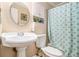 Bright bathroom featuring a pedestal sink, commode, and modern tiled shower/tub with curtain at 3998 Wabash Ln, Ellenwood, GA 30294