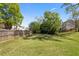 Large grassy backyard with mature trees and a wooden fence at 826 Buffington Way, Canton, GA 30115