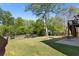 Large grassy backyard with mature trees, a fire pit, and a patio at 826 Buffington Way, Canton, GA 30115