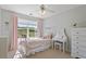 Bright bedroom features a bed, dressing table, large window, and neutral carpet at 826 Buffington Way, Canton, GA 30115