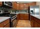 Modern kitchen featuring stainless steel appliances, tile backsplash, and rich wood cabinetry at 826 Buffington Way, Canton, GA 30115
