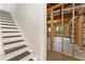 Staircase leading to the unfinished basement with concrete floors and exposed beams at 1740 Manhasset Pl, Atlanta, GA 30338