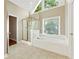 Bathroom featuring a soaking tub, separate shower with glass door, and large window at 1740 Manhasset Pl, Atlanta, GA 30338